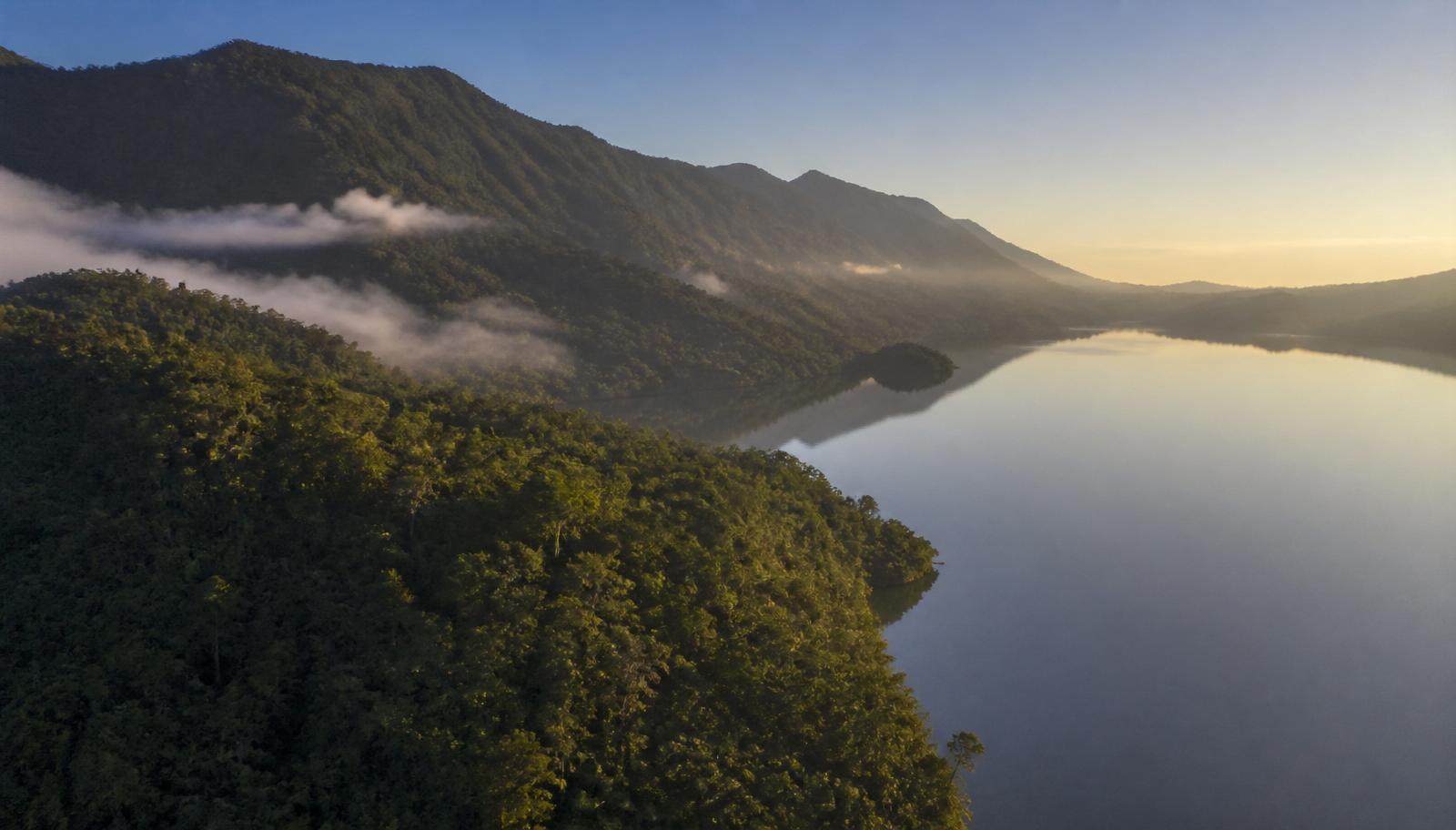 Vista aérea da Serra do Tabuleiro com mata atlântica encontrando a Lagoa de Imaruí ao amanhecer